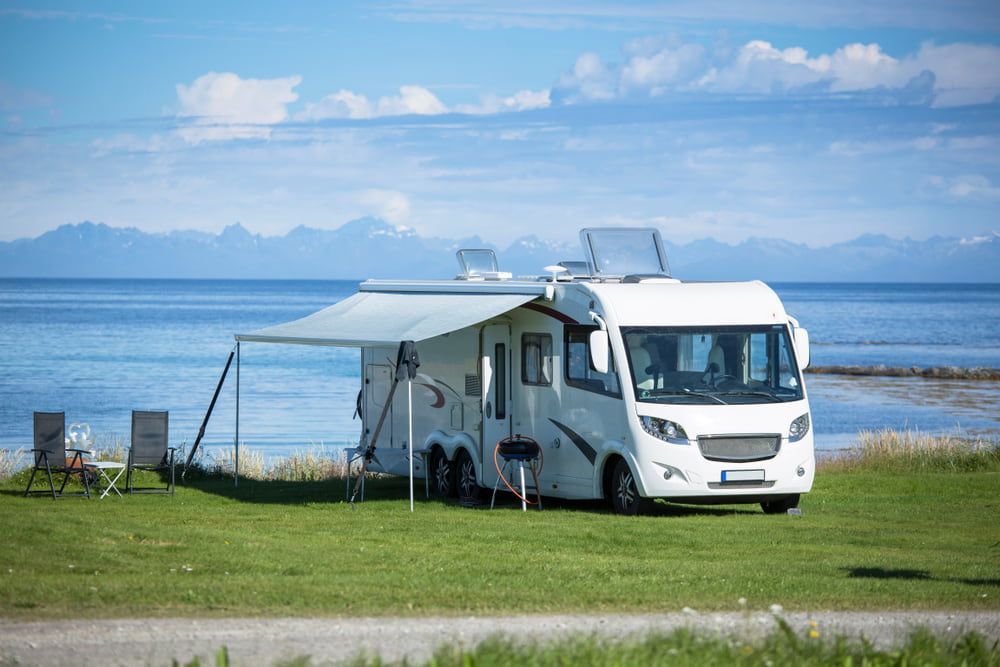 White Rv Parked on Green Grass by The Ocean Awning Extended — Darwin Caravan & RV Centre In Berrimah, NT