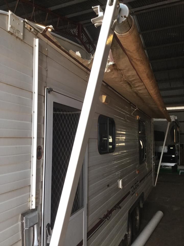 Side view of a caravan with an extended awning. The awning is beige and the caravan is white with a red stripe  — Darwin Caravan & RV Centre In Berrimah, NT