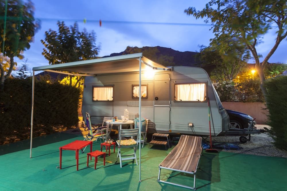 A Caravan with A Table, Chairs and A Sun Lounger Under an Awning — Darwin Caravan & RV Centre In Berrimah, NT