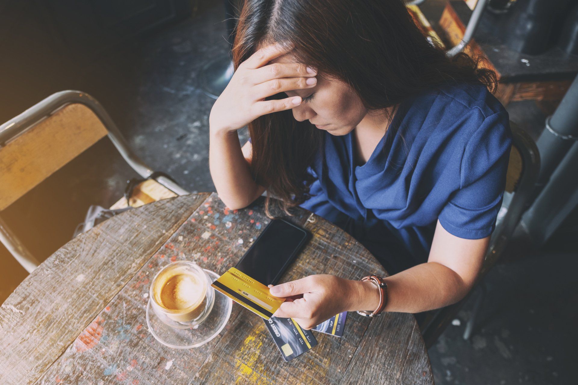 Woman looking stressed while holding credit card