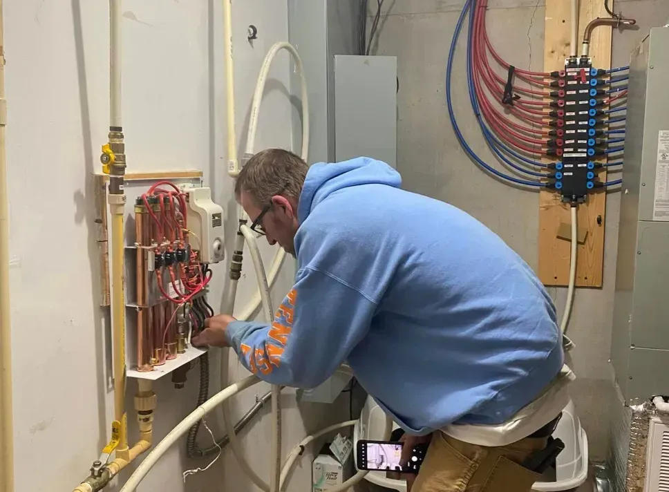 A man is working on an electrical box in a room.