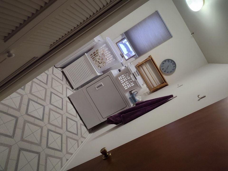 A laundry room with a clock on the wall