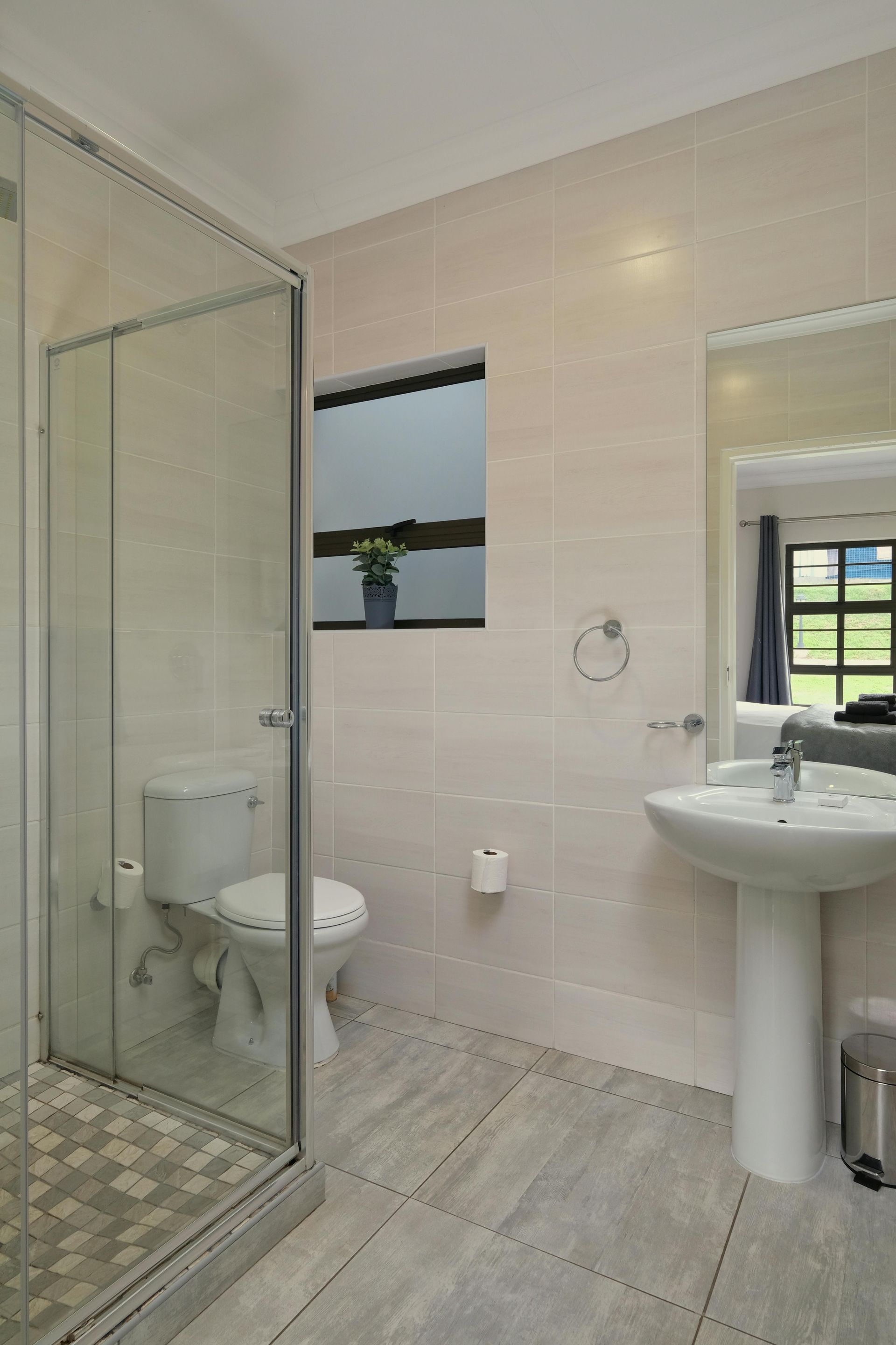 A bathroom with a toilet , sink , and shower.