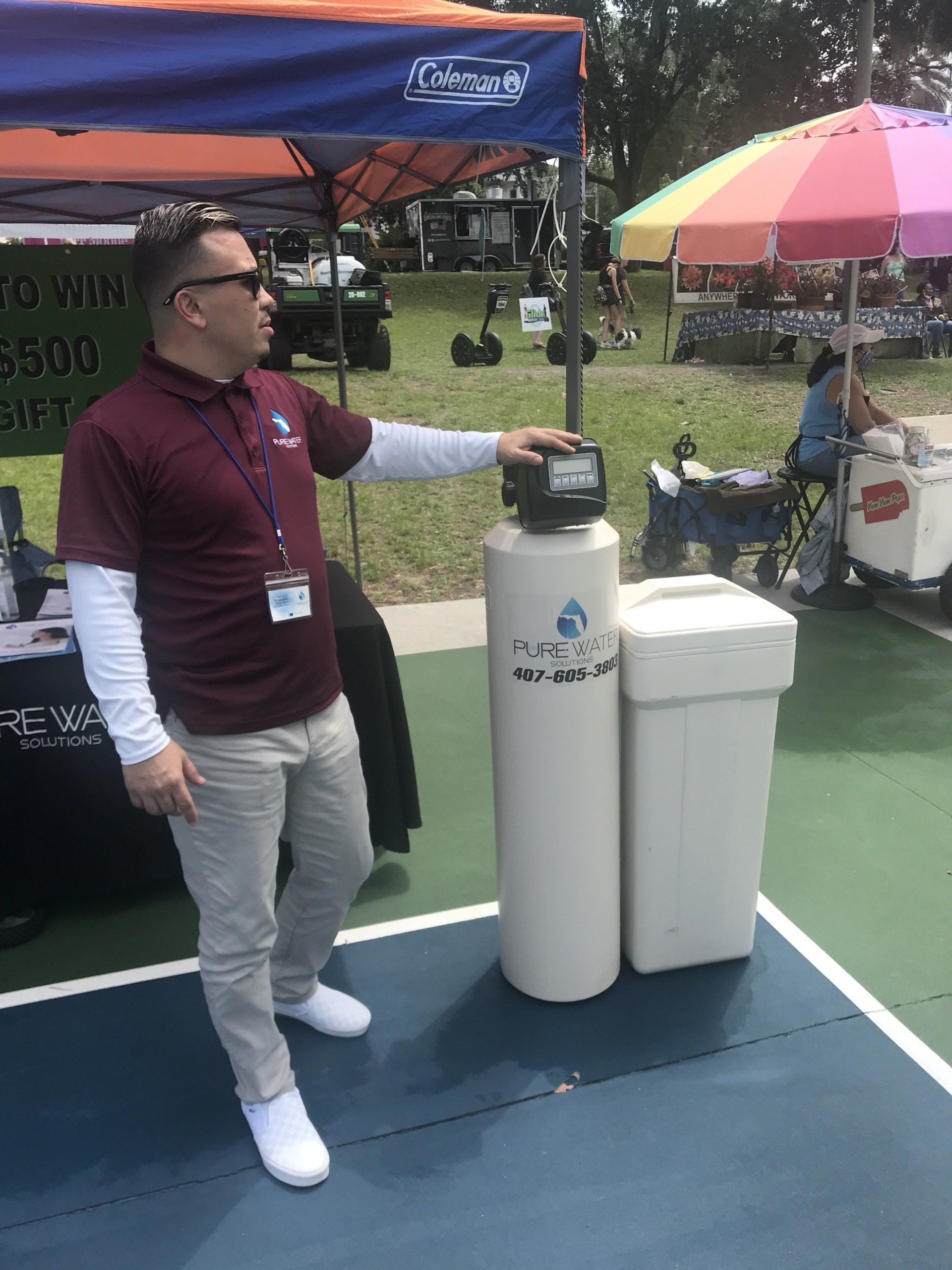 Man on Booth Holding Filtration System — Orlando, FL — Florida Pure Water Solutions