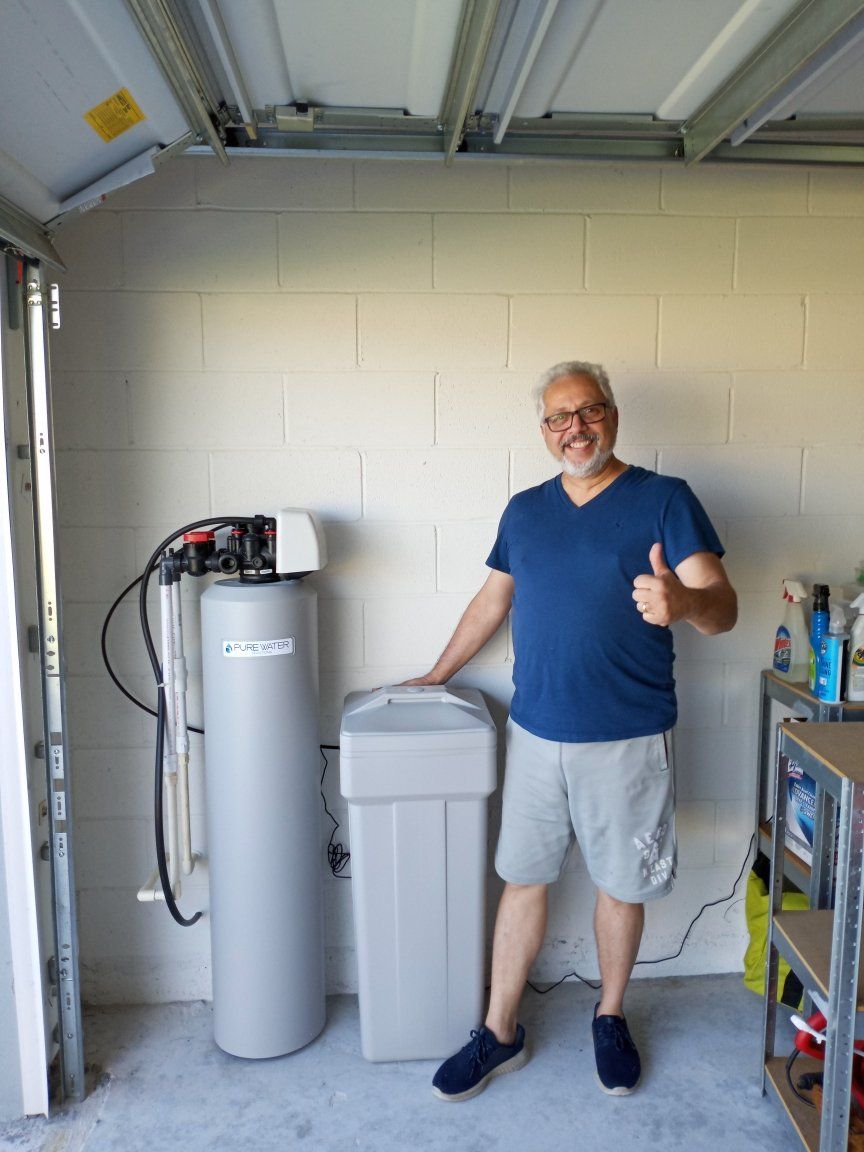 Man Smiling while Touching the Filter — Orlando, FL — Florida Pure Water Solutions