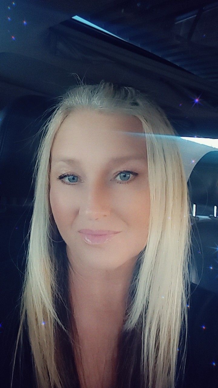 A woman is sitting in the back seat of a car.