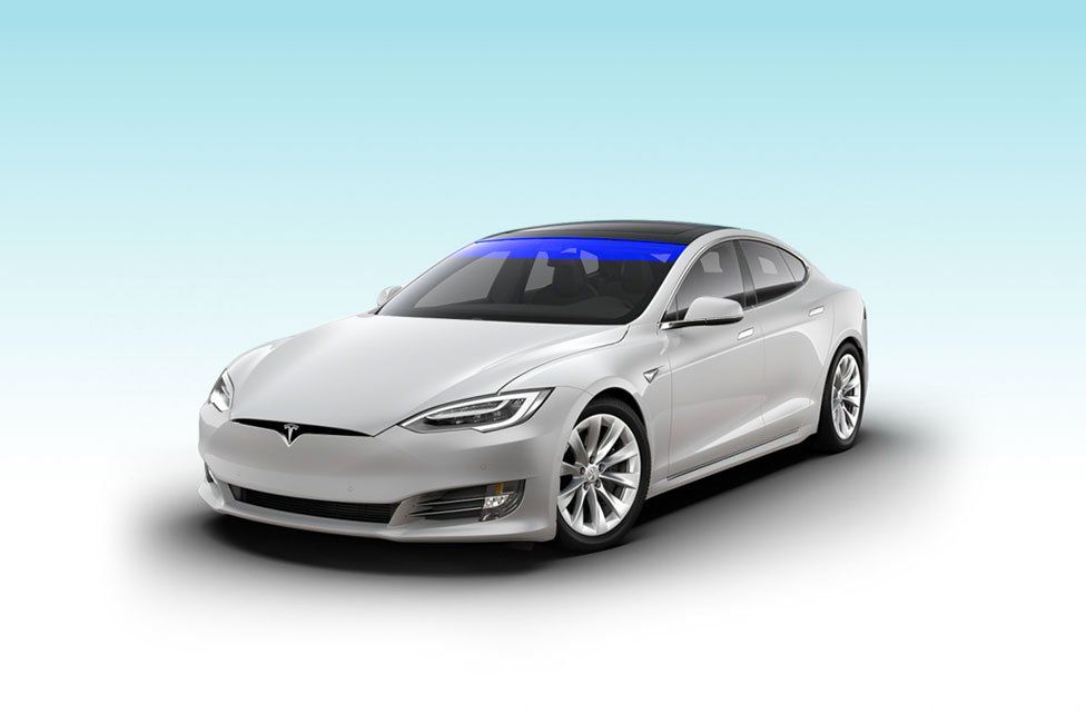 A white tesla model s with a blue sky in the background.
