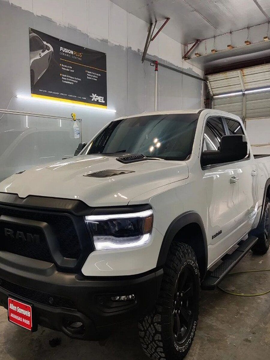 A white ram 1500 truck is parked in a garage.