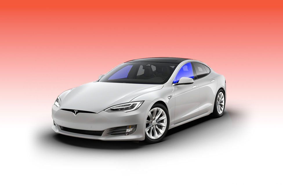 A white tesla model s is sitting on a red background.
