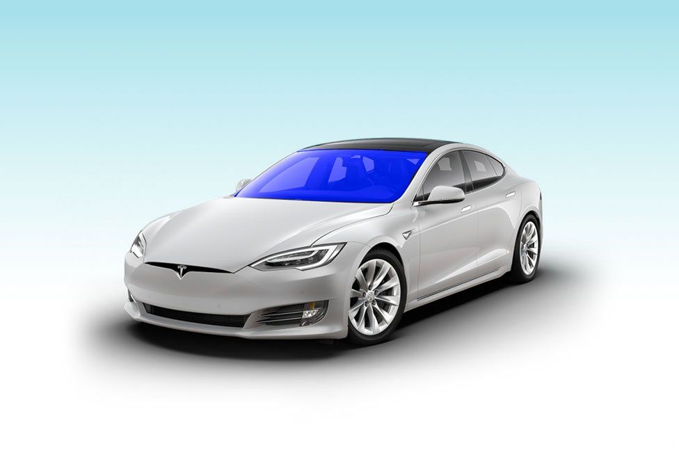 A white tesla model s with a blue sky in the background.