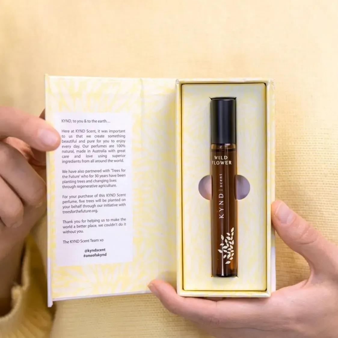 Person Holding Open a Yellow Box With a Rollerball Perfume Bottle Inside — Decadence Gifts & Homewares in Springsure, QLD