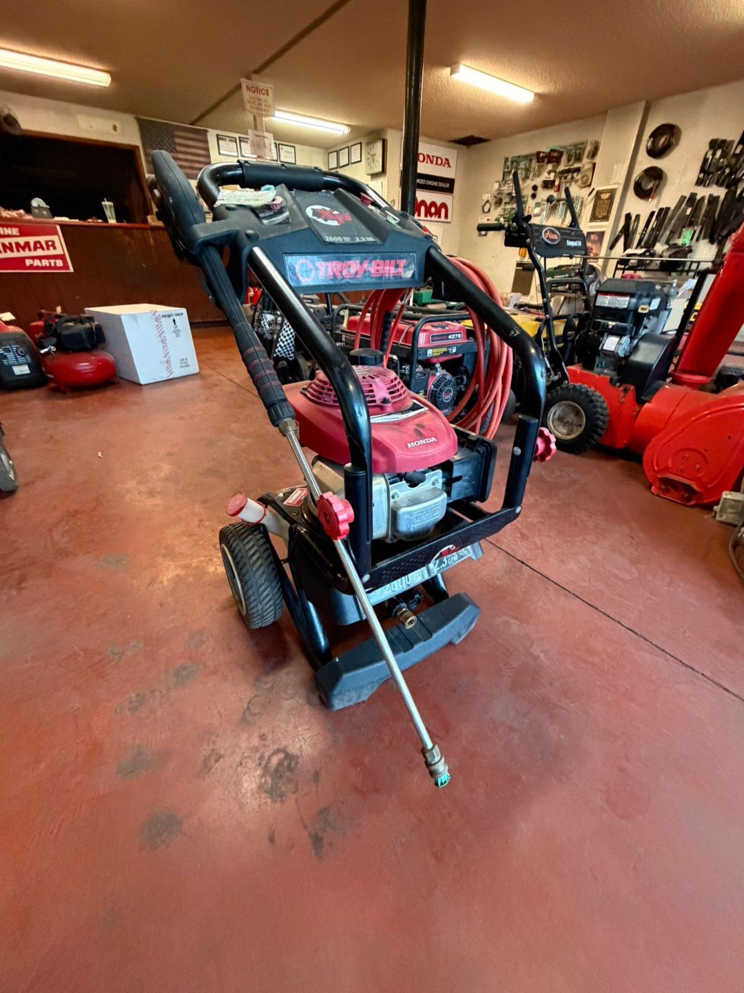 Person power washing a brick patio with yellow boots.