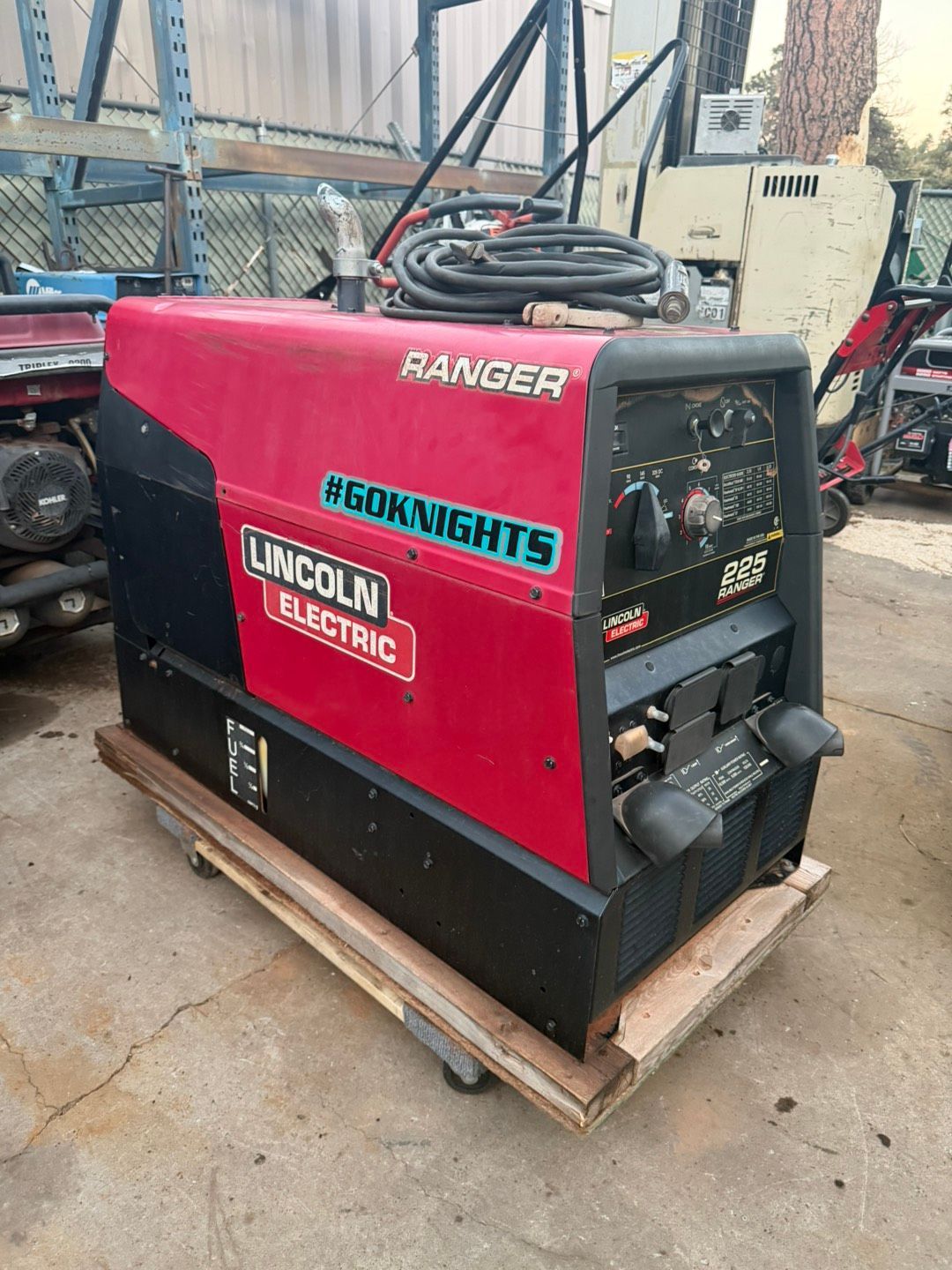 Welder cutting metal pipe, sparks flying, wearing protective gear.