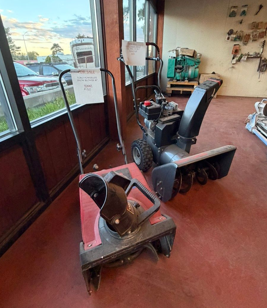 Close-up of a machine's motor with cooling fins, hoses, and wiring.