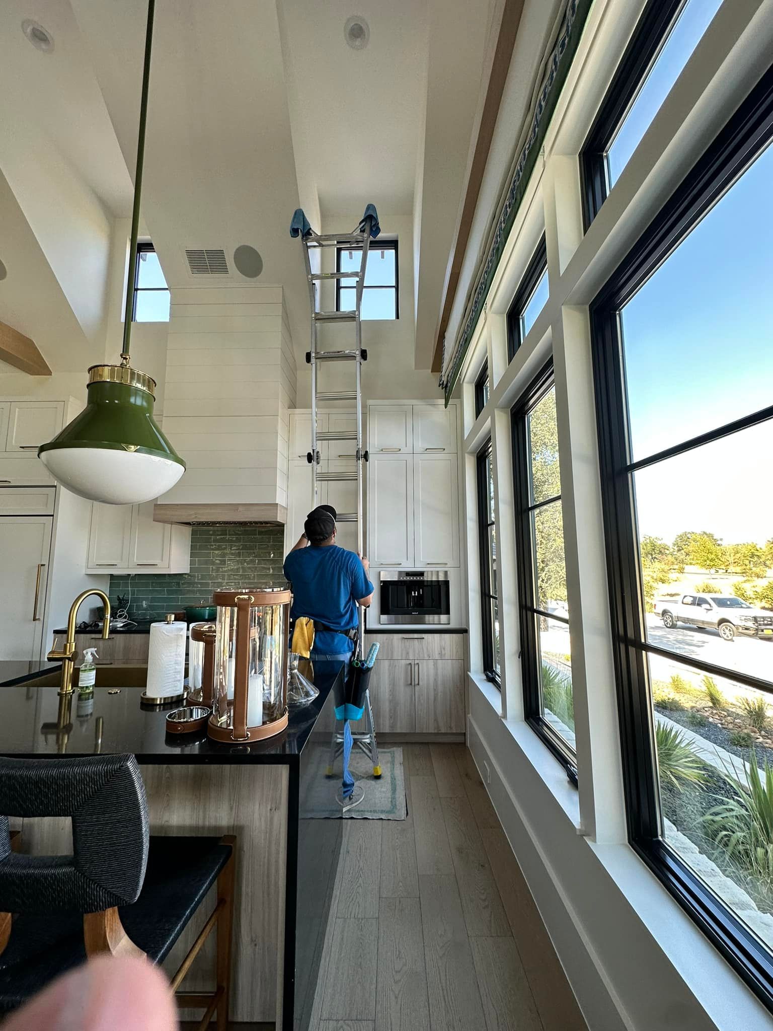 A man is standing on a ladder in a kitchen.