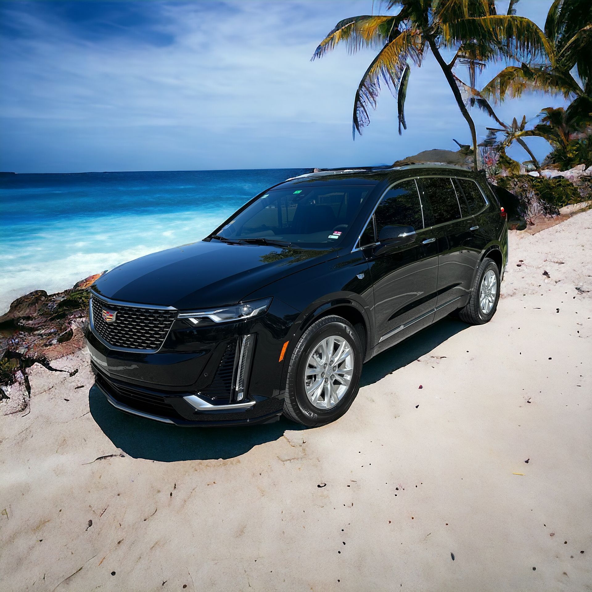 A black cadillac is parked on the beach near the ocean