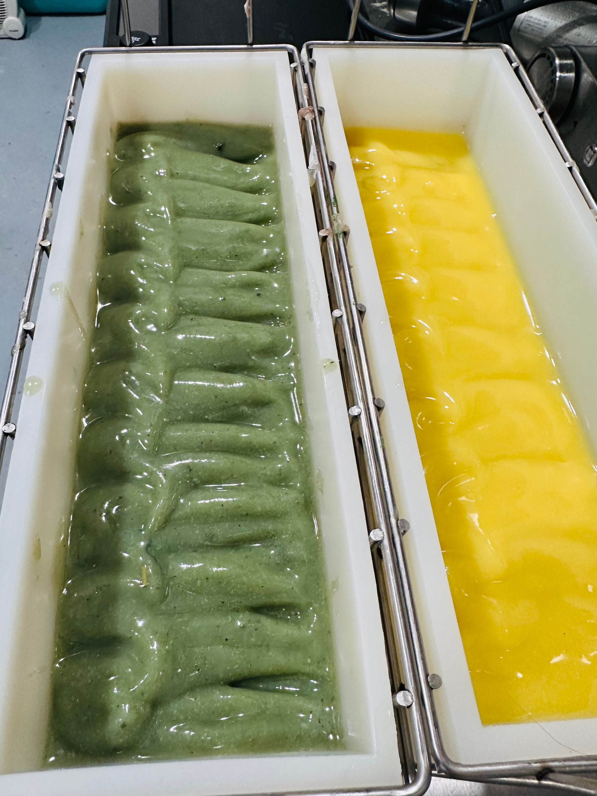 Two containers of green and yellow liquid are sitting on a table.