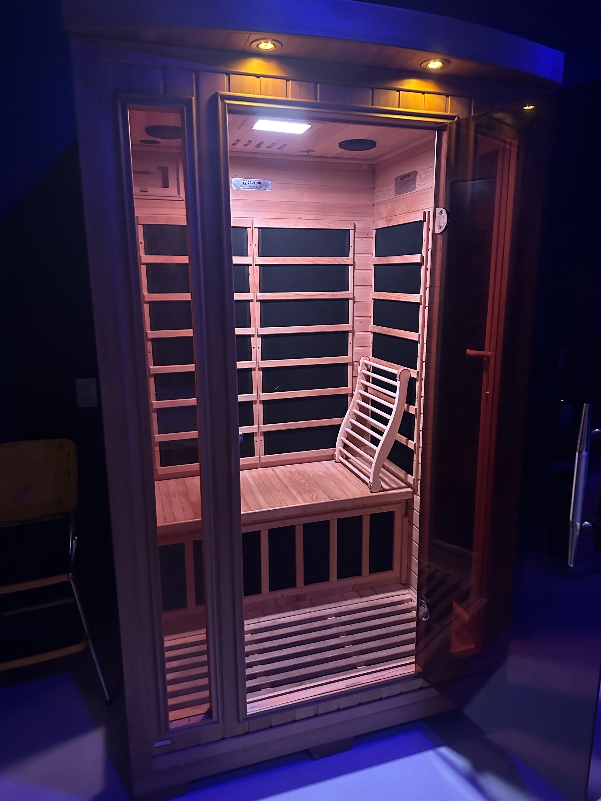 A wooden sauna with a chair inside of it