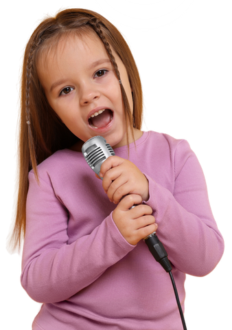 Niña cantando en un micrófono plateado, con una camisa rosa y la boca abierta.