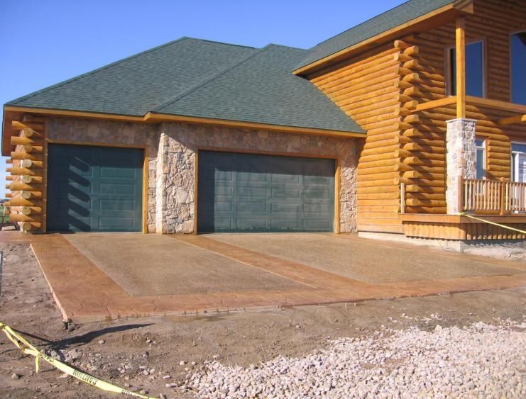 A large log cabin with a green garage door