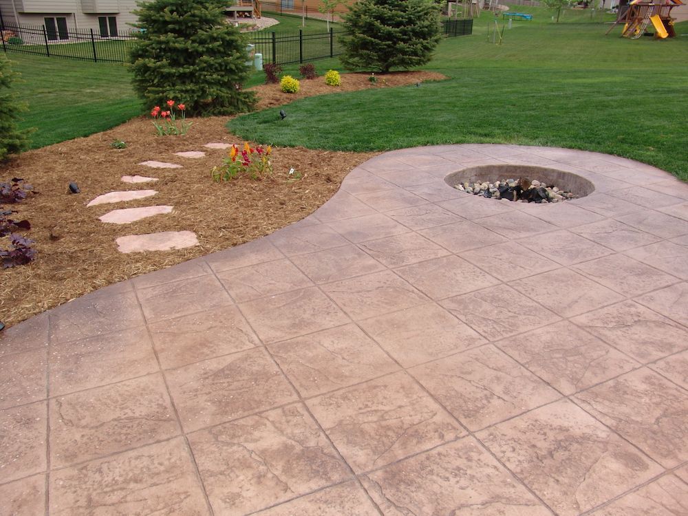 A patio with a fire pit in the middle of it