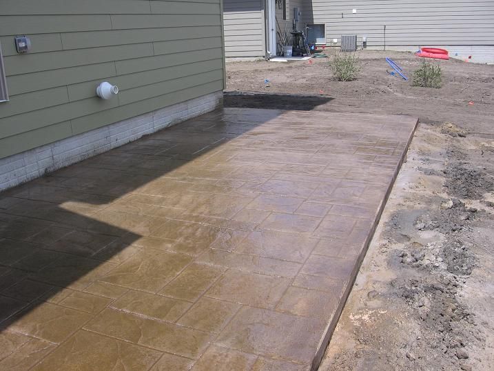 A concrete walkway is being built in front of a house.