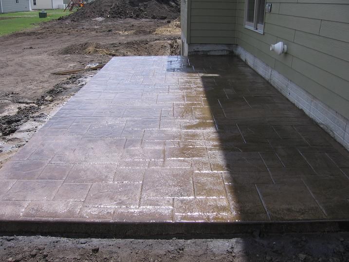 A concrete walkway is being built in front of a house