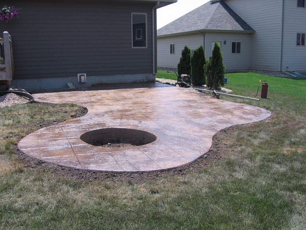 A patio with a fire pit in the middle of it