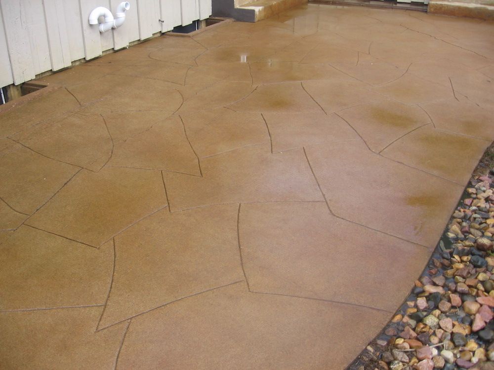 A brown concrete floor with a white fence in the background