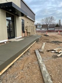 A concrete walkway is being built in front of a building.
