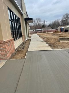 A concrete walkway is being built in front of a building.