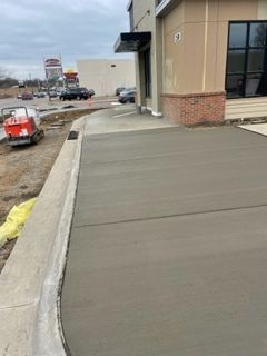 A concrete sidewalk is being built in front of a building.