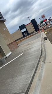 A concrete sidewalk leading to a fast food restaurant.