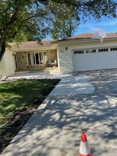 A basketball hoop is hanging from the garage door of a house.