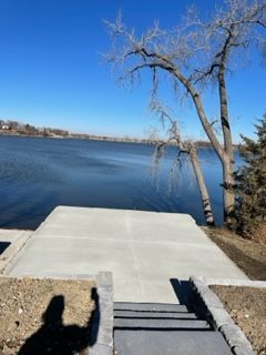 A concrete dock with stairs leading to a lake