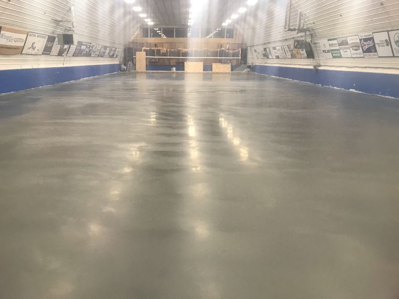 A large empty warehouse with a concrete floor and blue walls.