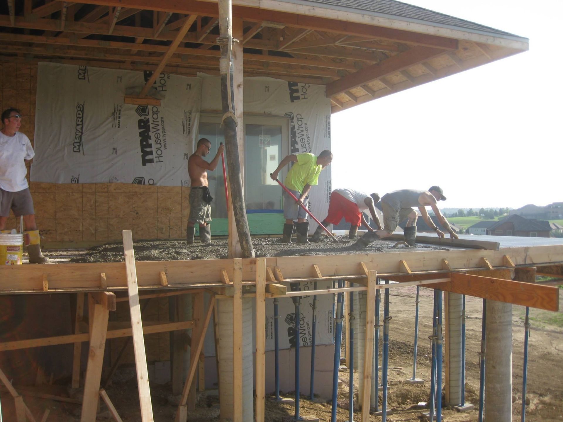 A group of construction workers are working on a house under construction