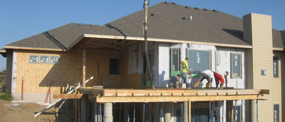 A group of construction workers are working on a house under construction