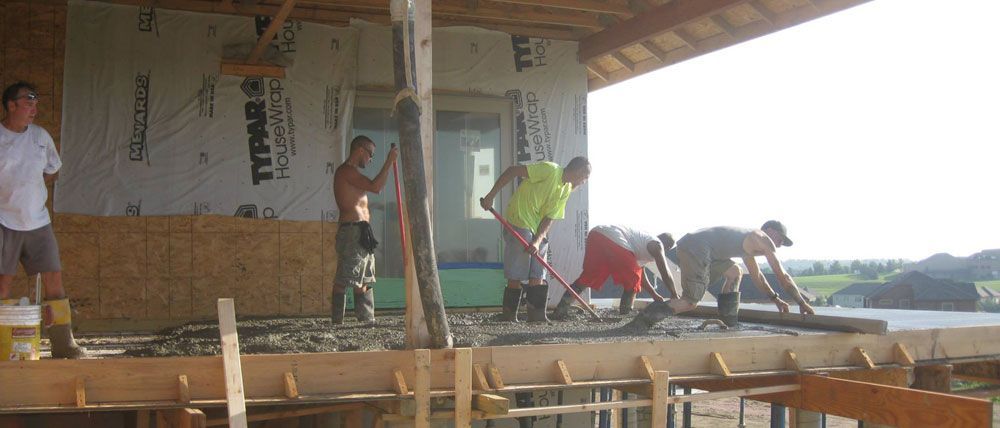 A group of men are working on a building with styrofoam on the wall