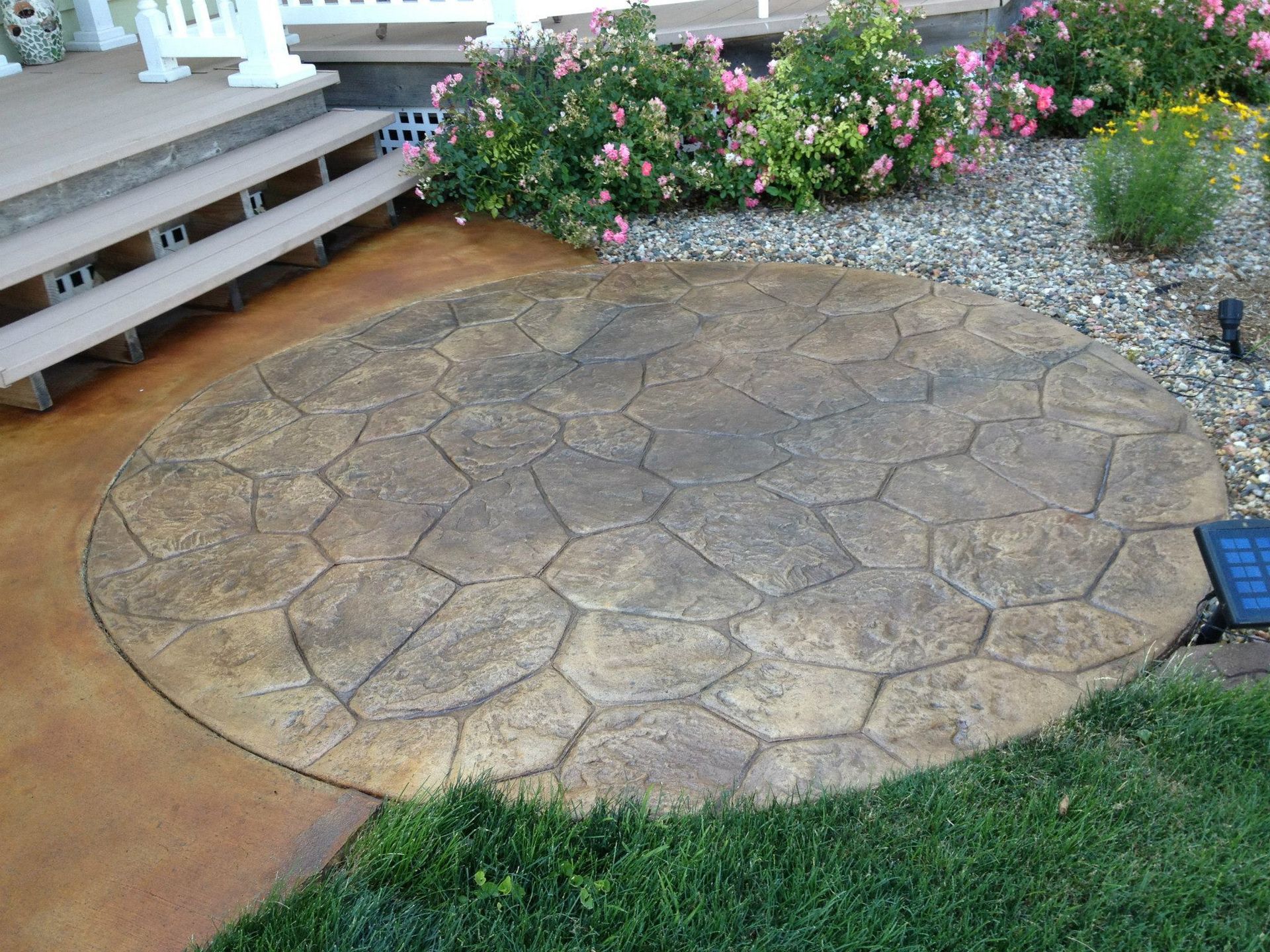 A circular concrete walkway with a solar light in the middle