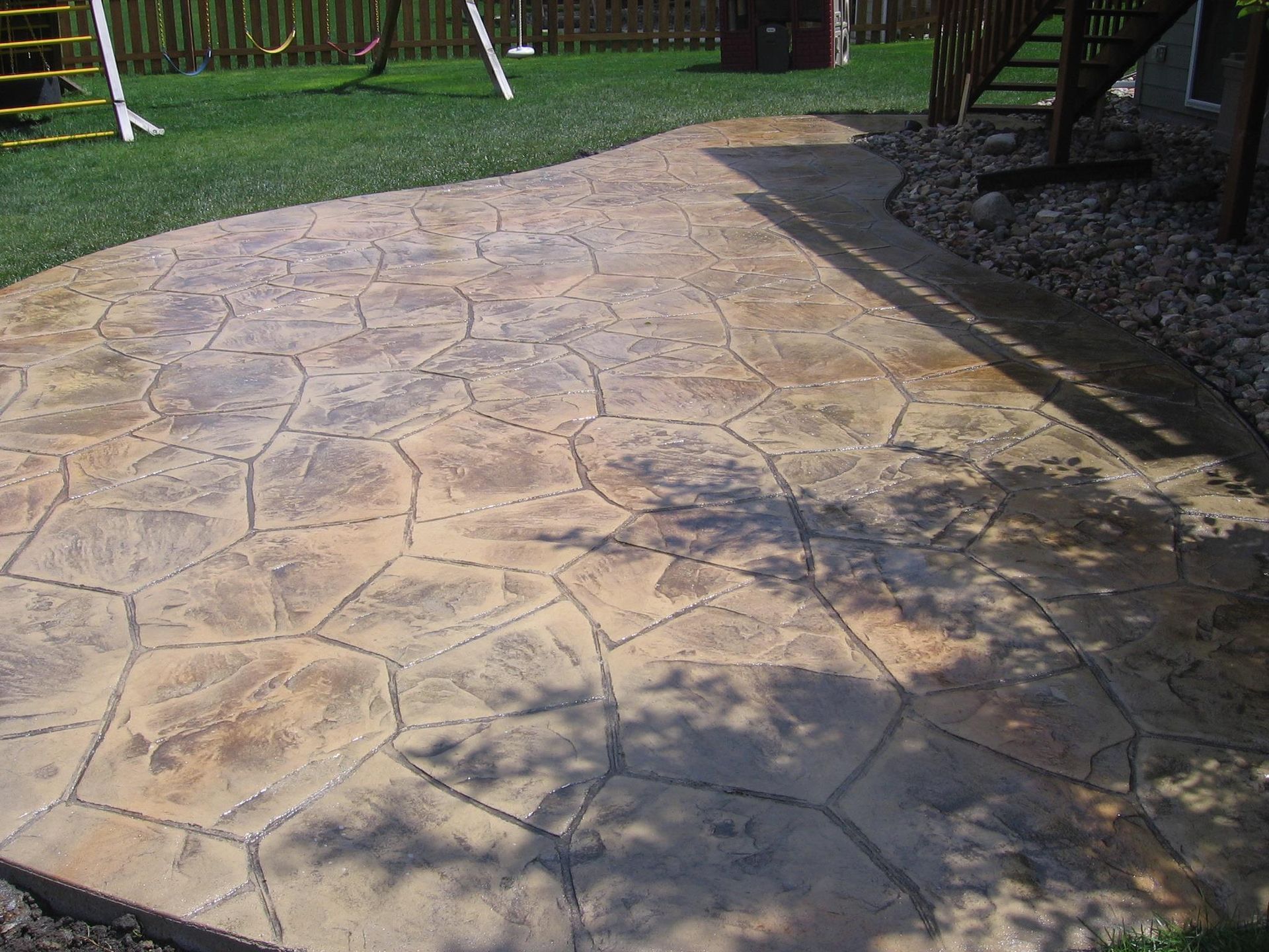 A patio with a swing set in the background