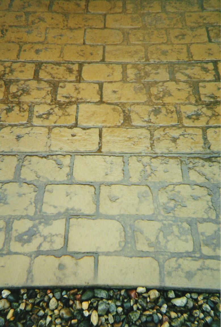 A close up of a brick walkway with rocks in the background