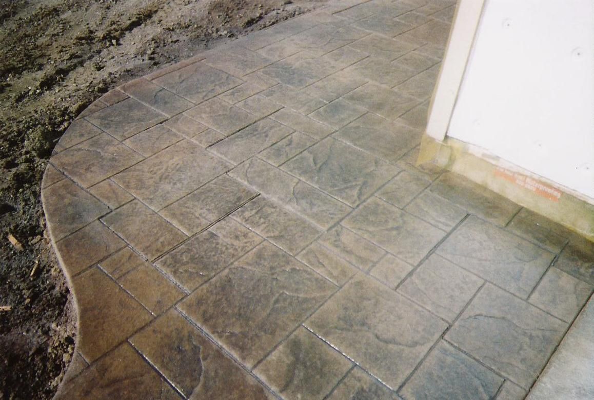 A concrete walkway with a brick pattern on it