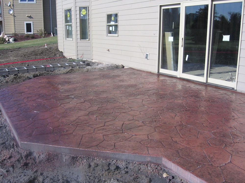 A patio in front of a house with sliding glass doors