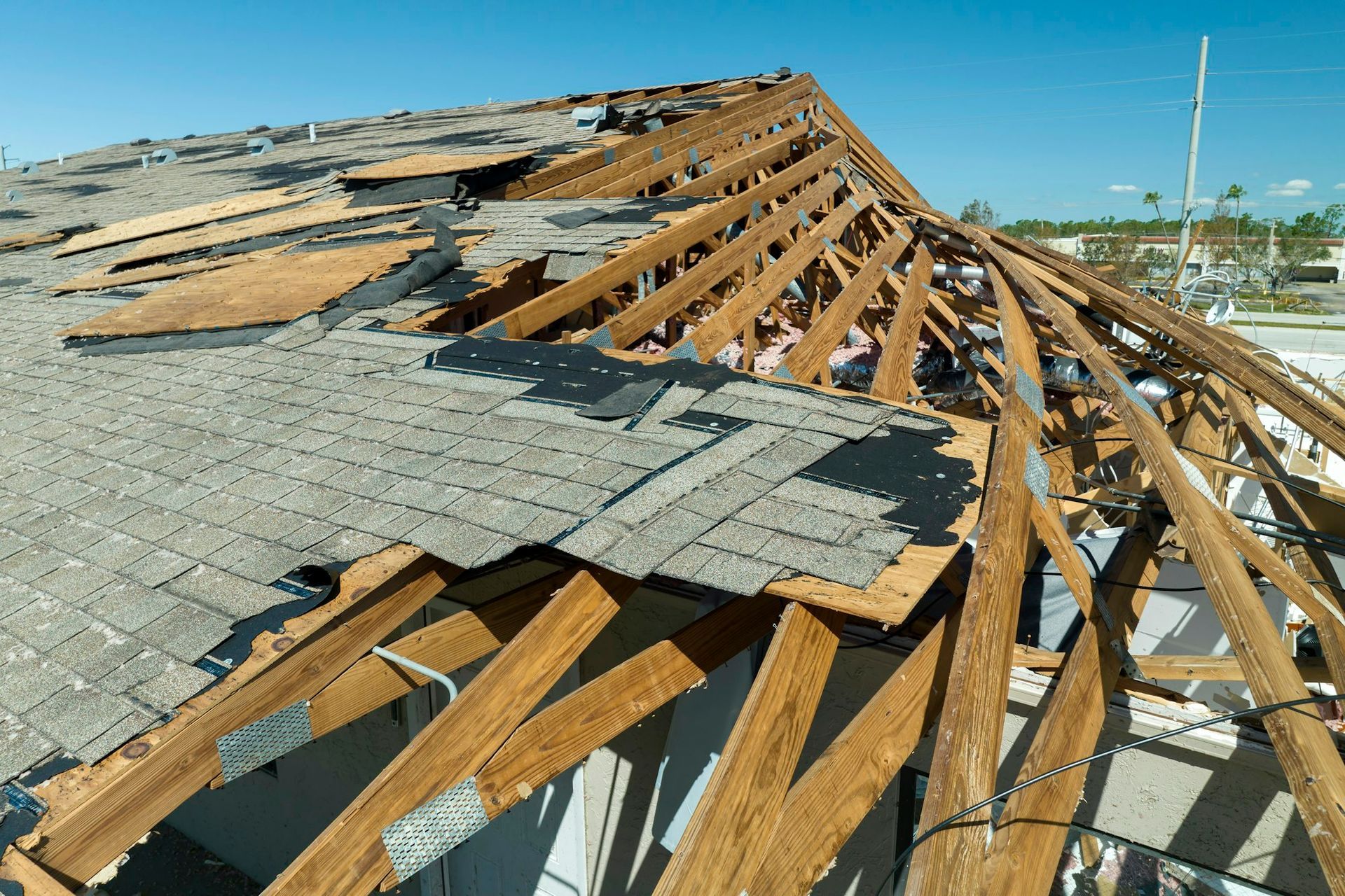 damaged house roof with missing shingles after hurricane 