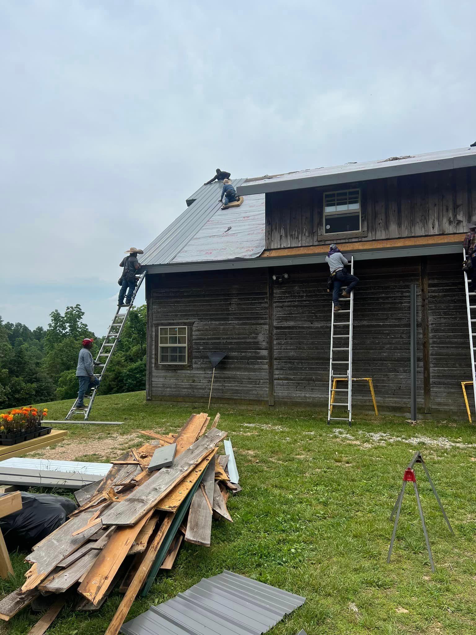 A group of people are working on the roof of a wooden house.
