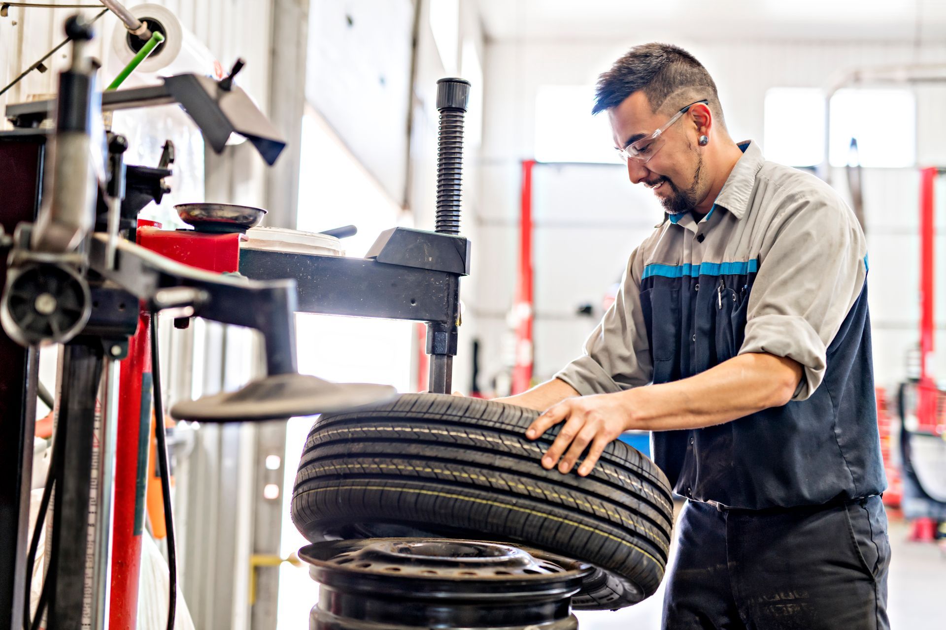 Mechanic mounting a tire in a repair shop.