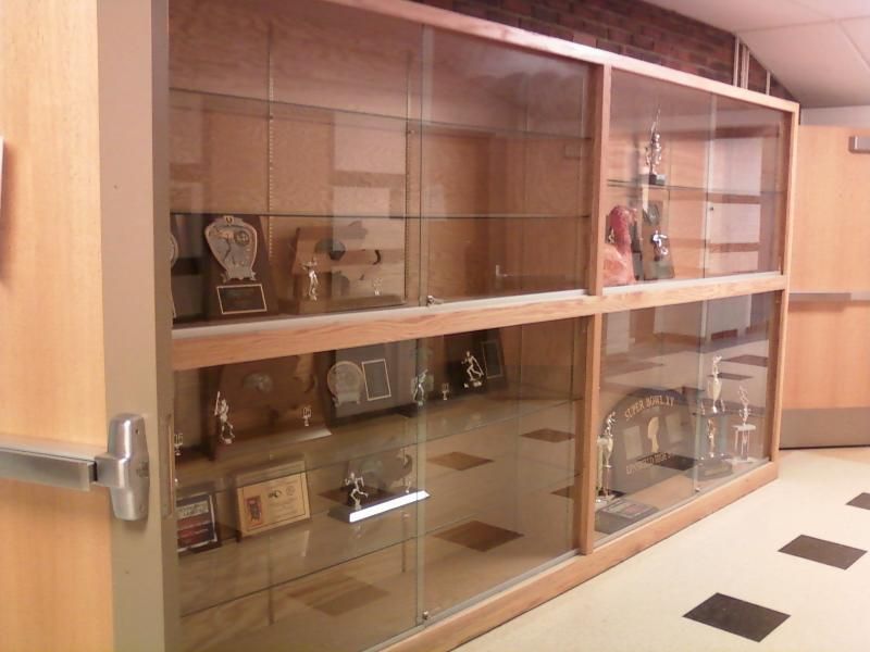 Wooden trophy cases in a school hallway, showcasing awards and achievements.