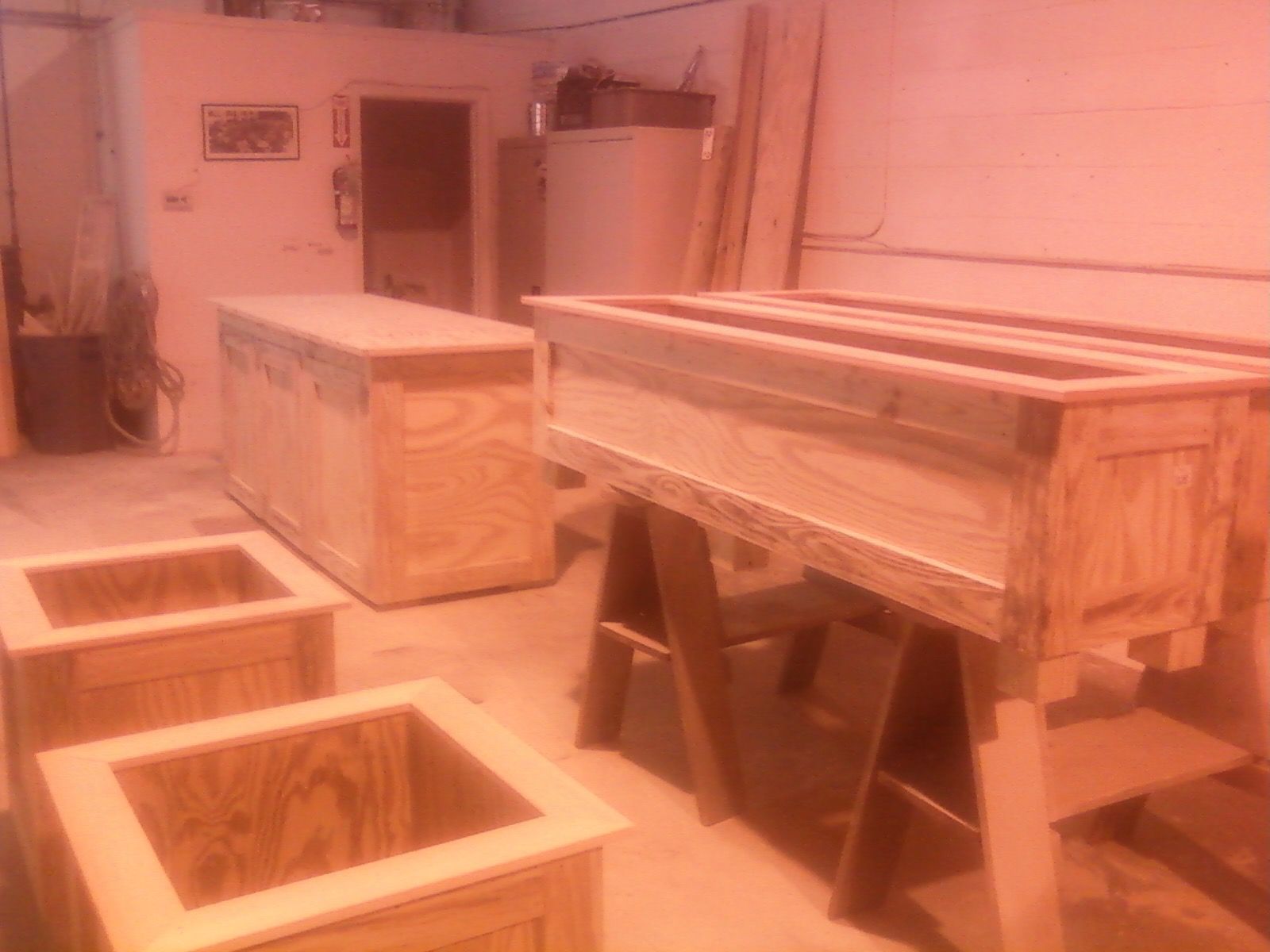 Wooden boxes in a workshop setting, some finished, others in progress.
