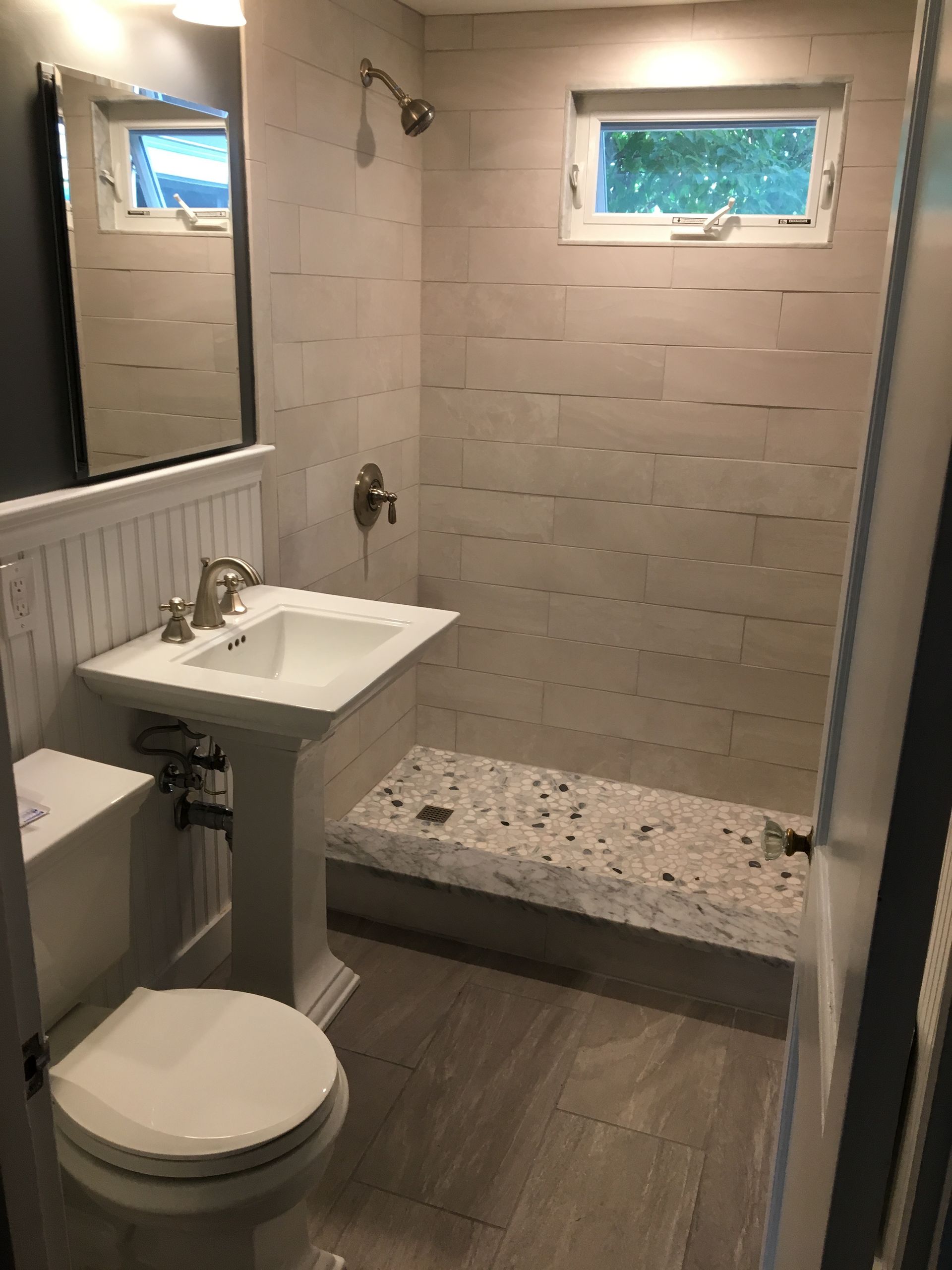 Small bathroom with a pedestal sink, toilet, and tiled shower.